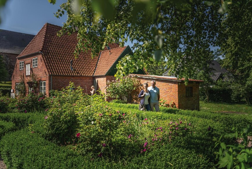 Paar spaziert das grün bewachsene Tetenbüll