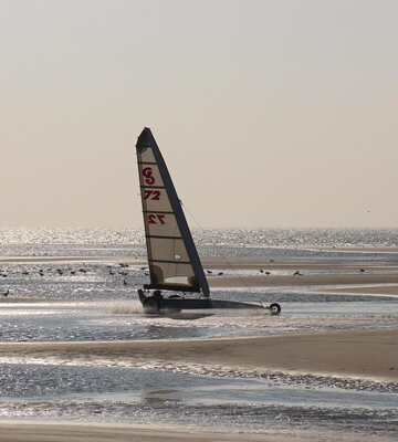 Strandsegler am weiten Strand bei Abendsonne