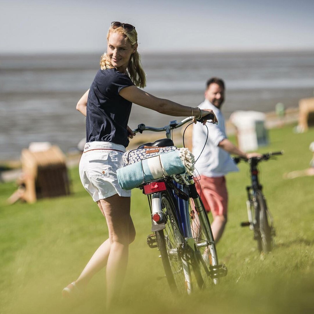 Fahrradtour eines Paares an den Deich der Badestelle Vollerwiek