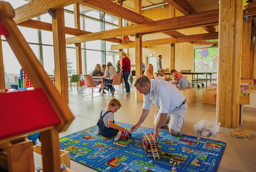 Vater und Sohn beim Spielen auf dem Spieleteppich im Spiele-Hus