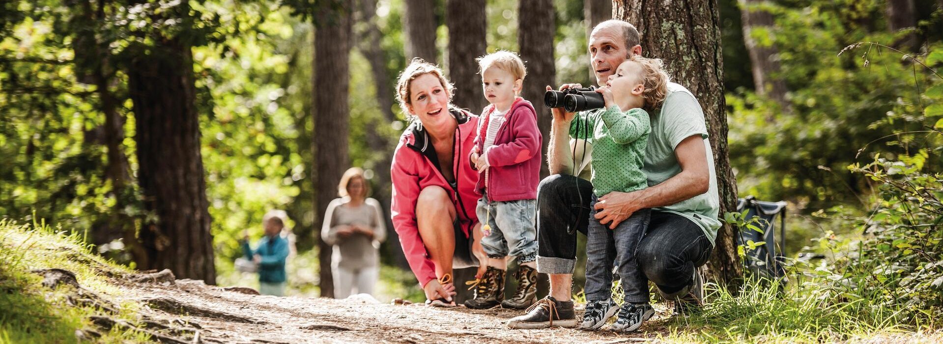 Familie auf Abenteuern mit Fernglas im Wald