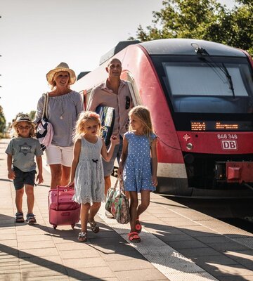 Familie reist am Bahnhof an