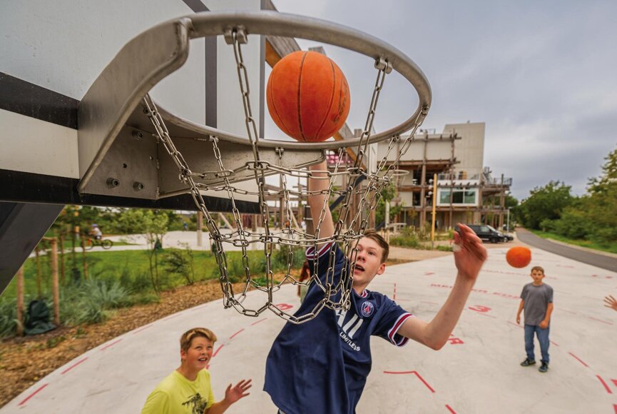 Teenager beim Basketball Spielen vor dem Erlebnis-Hus