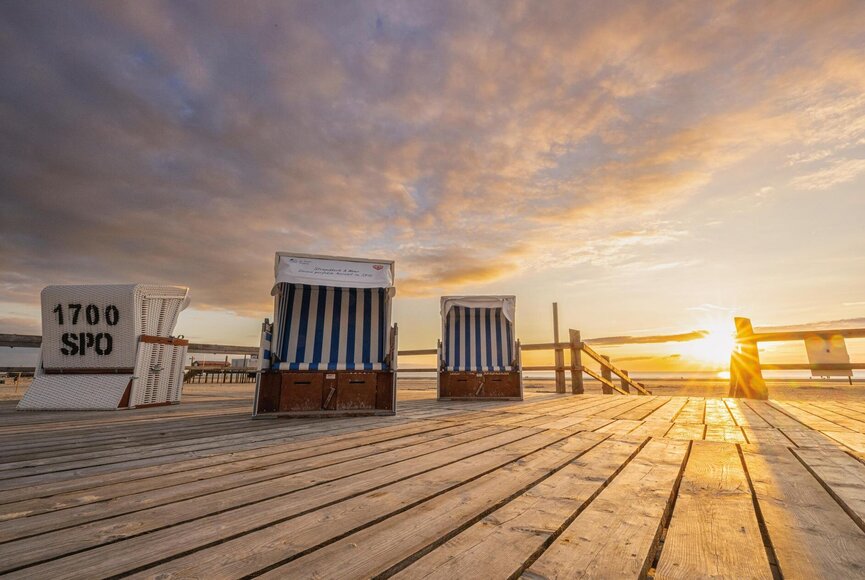 Strandkörbe auf dem Podest im Sonnenuntergang