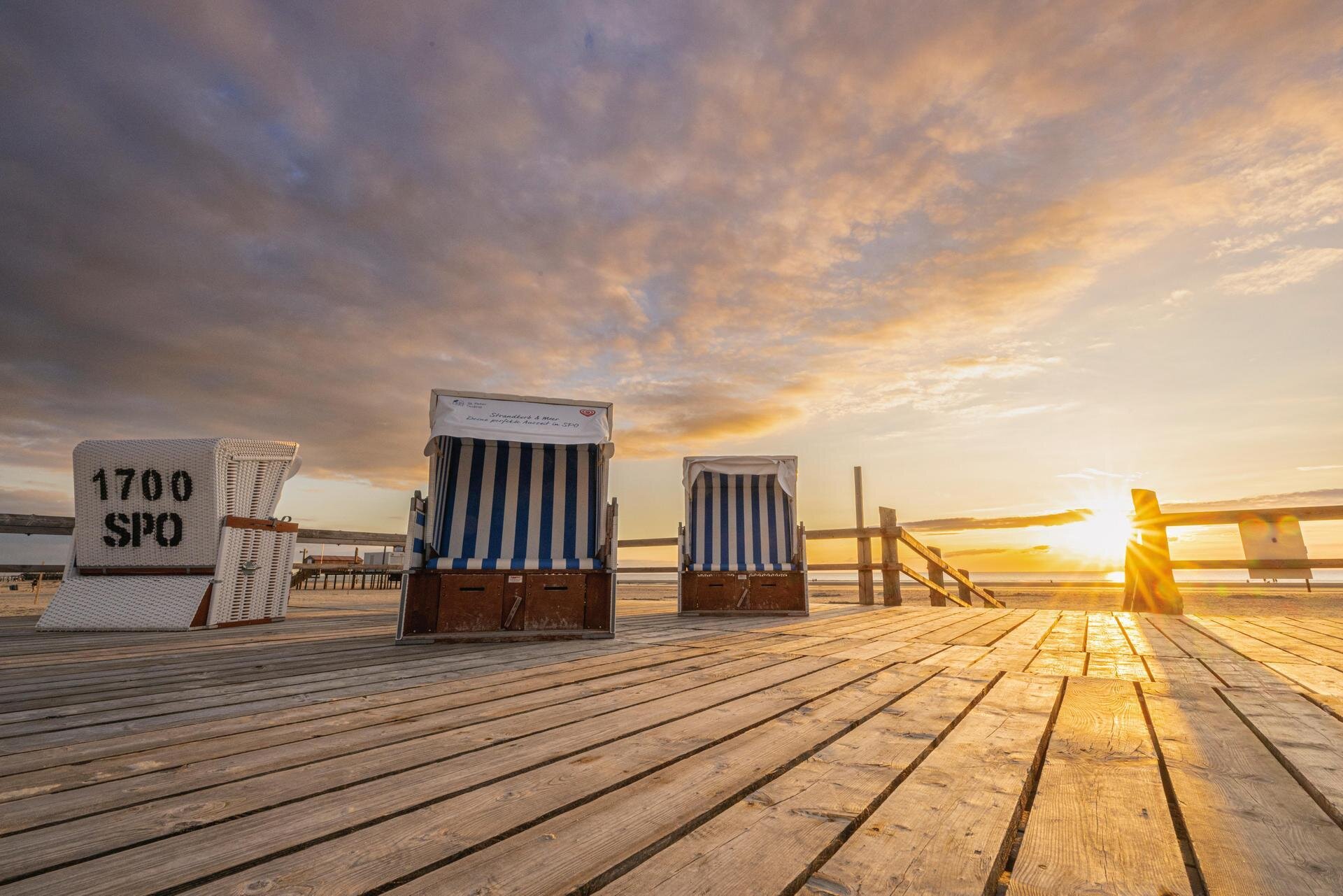 Strandkörbe auf dem Podest beim Sonnenuntergang