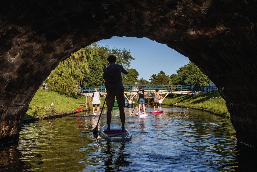 Mit dem SUP unter einer Brücke in Friedrichstadt fahren