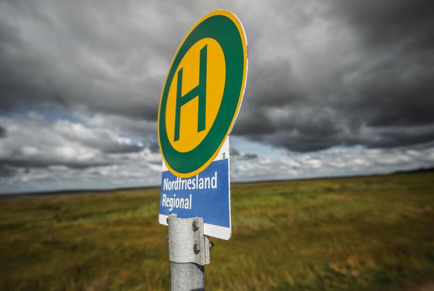 Haltestellen-Schild vor grüner Salzwiese