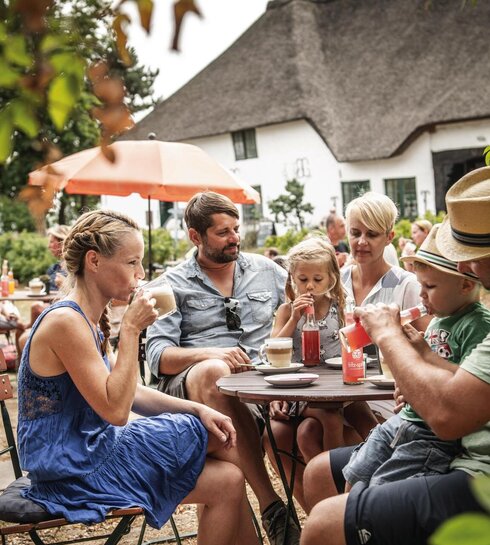 Familie im Garten eines Hofcafés